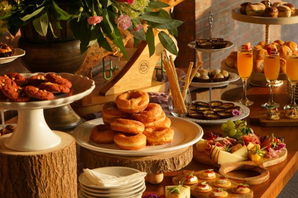 Sumptuous brunch spread featuring diverse pastries, fresh fruits, and elegant floral arrangements.